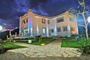 a large white house at night with a stone driveway at Casamediterranea in Sperlonga