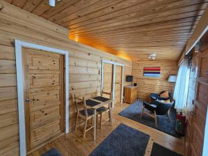 een houten kamer met een tafel en stoelen en een deur bij Luppoloma in Saariselkä