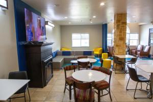 a waiting room with tables and chairs and a couch at Microtel Inn & Suites by Wyndham Searcy in Searcy