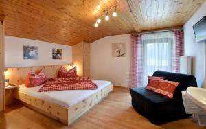 a bedroom with a bed and a couch and a sink at Haus Bianca in Stumm