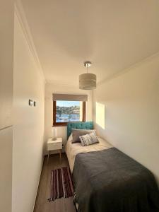 a small bedroom with a bed and a window at Confortable Dpto 2D y 2 baños in Los Ángeles