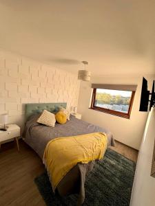 a bedroom with a bed with yellow sheets and a window at Confortable Dpto 2D y 2 baños in Los Ángeles