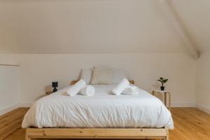 een wit bed met witte lakens en kussens erop bij Setúbal Terrace apartments in Setúbal