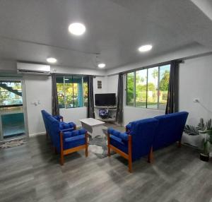 een woonkamer met blauwe stoelen en een tv bij Drasa Homestay in Lautoka
