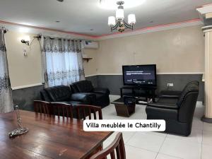 sala de estar con mesa y TV en Dany Chantilly en Yaundé