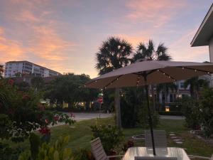 an umbrella sitting on a table in a park at Closest Studio Suite to Vanderbilt Beach, new remodel, well appointed, BBQ, yard, very private plus many extras! in Naples