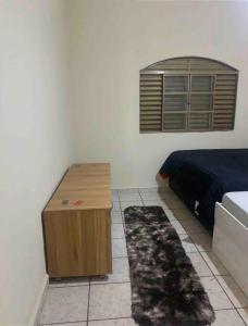 1 dormitorio con cama y mesa de madera en Casa de Férias 1purbana en Ribeirão Preto