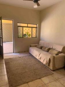 uma sala de estar com um sofá e uma janela em Casa de Férias 1purbana em Ribeirão Preto