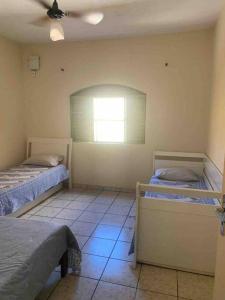a room with two beds and a window at Casa de Férias 1purbana in Ribeirão Preto