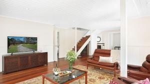 ein Wohnzimmer mit Sofa und Tisch in der Unterkunft Southrose Cottage in Moss Vale