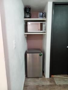 a small refrigerator in a small room with a microwave at Loft Santa rosa in Apizaco