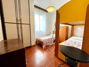 a room with two bunk beds and a table at Comfy flat with terrace 250mt from the sea in Porto Santa Margherita di Caorle +15 photos