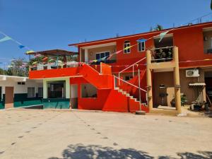 een rood gebouw met een trap aan de zijkant bij Posada Playa Linda in Ixtapa