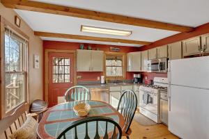 cocina con mesa y nevera blanca en A Cozy 2BR Log Cabin Getaway-Mirror Lake-Fireplace cabin, en Lake Lure