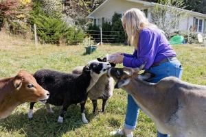 une femme pèche deux chèvres dans l'établissement -Mountain Views-Great location-Near DuPont and Pisgah Forest home, à Etowah