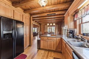 eine Küche mit Holzschränken und einem schwarzen Kühlschrank in der Unterkunft Vacation cabin in Lake Lure - Mirror Lake - great family space! W-Fi cabin in Lake Lure
