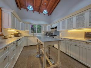 a large kitchen with white cabinets and a table at Villas Valle in Valle de Bravo