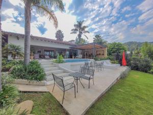 a patio with tables and chairs and a swimming pool at Villas Valle in Valle de Bravo