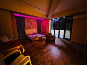 une chambre avec un lit et une chambre avec des lumières roses dans l'établissement Secrets Room Baku, à Baku
