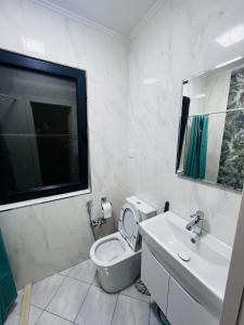 La salle de bains blanche est pourvue de toilettes et d'un lavabo. dans l'établissement Secrets Room Baku, à Baku