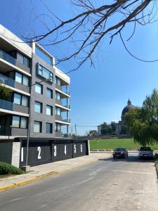 Costanera4 في سان نيكولاس دي لوس أرويوس: سيارتين متوقفتين امام مبنى