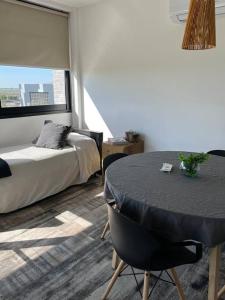 Costanera4 في سان نيكولاس دي لوس أرويوس: غرفة بها سرير وطاولة وكراسي