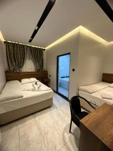 1 dormitorio con 2 camas, mesa y silla en Antik Otel, en Kayacık
