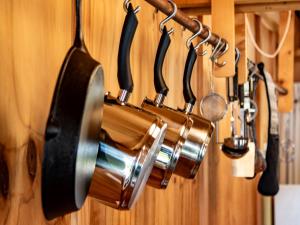 a pot and pans hanging on a wall at The Gatehouse - Takaka Holiday Home in Takaka