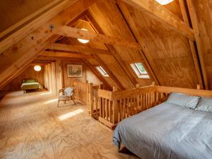 um quarto com uma cama num chalé de madeira em The Gatehouse - Takaka Holiday Home em Takaka