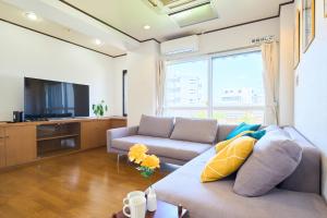 a living room with a couch and a tv at Near Shibuya! 150 sq m Private floor & Japanese garden in Tamagawa
