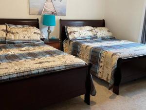 Duas camas sentadas uma ao lado da outra num quarto em Casa di Montagna/5BR/3Bath/NearResorts/PetsAllowed em Pocono Lake