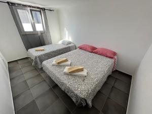 twee bedden in een kleine kamer met handdoeken erop bij ESTANQUEIRA GUEST HOUSE in Sines