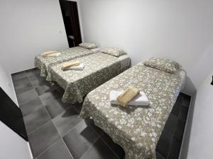 two beds in a room with a table with a tray at ESTANQUEIRA GUEST HOUSE in Sines