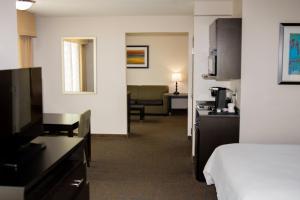 a hotel room with a bed and a living room at Holiday Inn Express & Suites Bakersfield Airport, an IHG Hotel in Bakersfield