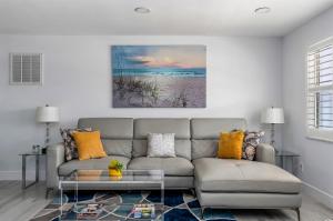 a living room with a couch and a painting on the wall at Secluded Family Serenity on Canal with 2 Bikes and Beach Chairs in Naples