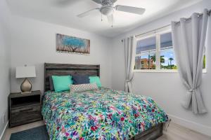 a bedroom with a bed and a ceiling fan at Secluded Family Serenity on Canal with 2 Bikes and Beach Chairs in Naples