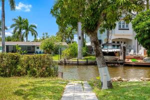 a house with a boat in the water at Secluded Family Serenity on Canal with 2 Bikes and Beach Chairs in Naples