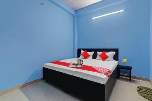 a blue bedroom with a bed with red pillows at OYO Flagship 70105 Hotel Pulick Awadh in Lucknow