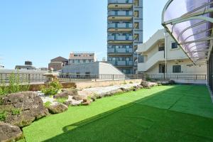a garden with green grass and a building at Near Shibuya! 150 sq m Private floor & Japanese garden in Tamagawa