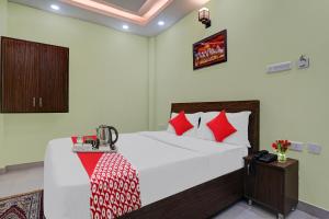 a bedroom with a bed with red and white pillows at OYO Flagship 70105 Hotel Pulick Awadh in Lucknow