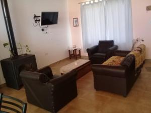 a living room with two couches and a tv at Cabaña de Emma in Villa Las Rosas