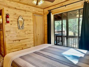 ein Schlafzimmer mit einem Bett in einem Blockhaus in der Unterkunft Whispering Pines in Overgaard