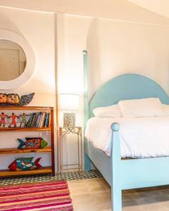 um quarto com uma cama azul e um espelho em Flower of Life em Puerto Viejo