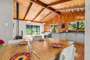 a kitchen and dining room with a wooden table at The Wee Bothy - Whangamata Holiday Home in Whangamata