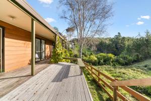 a wooden deck on the side of a house at The Wee Bothy - Whangamata Holiday Home in Whangamata