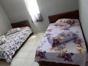 1 dormitorio con 2 camas individuales y ventana en Casa tchitchi, en São Filipe