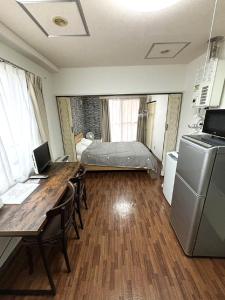 een kamer met een bureau en een bed in een kamer bij ローヤルハイツ菊水駅 in Sapporo