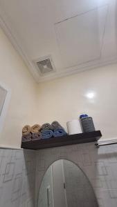 a shelf in a bathroom with toiletries and a mirror at Serene Mountain View Heights in Dipolog