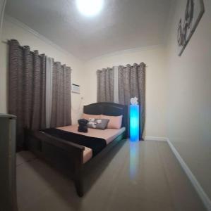 a bedroom with a bed and a blue light at Serene Mountain View Heights in Dipolog