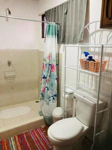 a bathroom with a toilet and a shower curtain at Hostel Casa Mar in Liberia